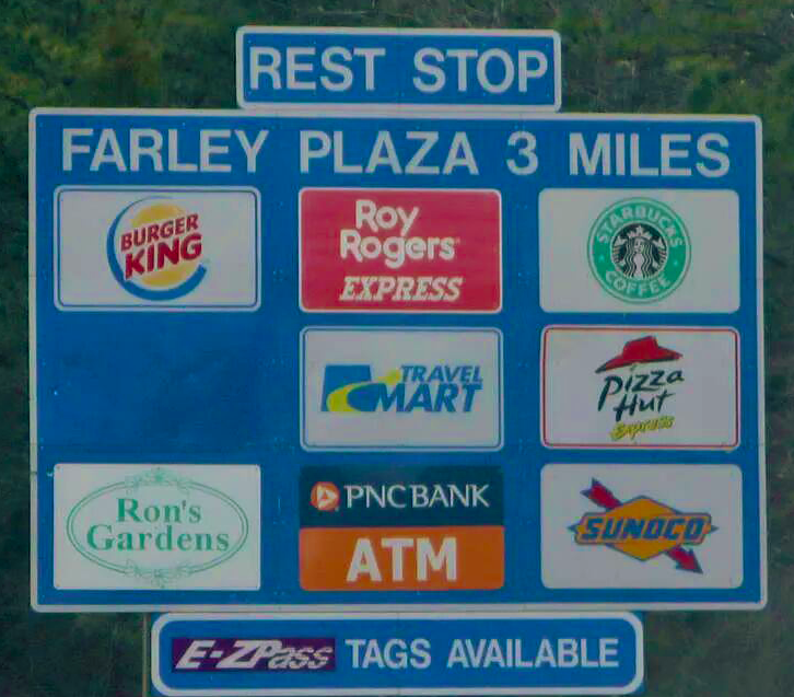 A blue highway sign for Farley Plaza, 3 miles away, listing businesses including Burger King, Starbucks, and Sunoco.