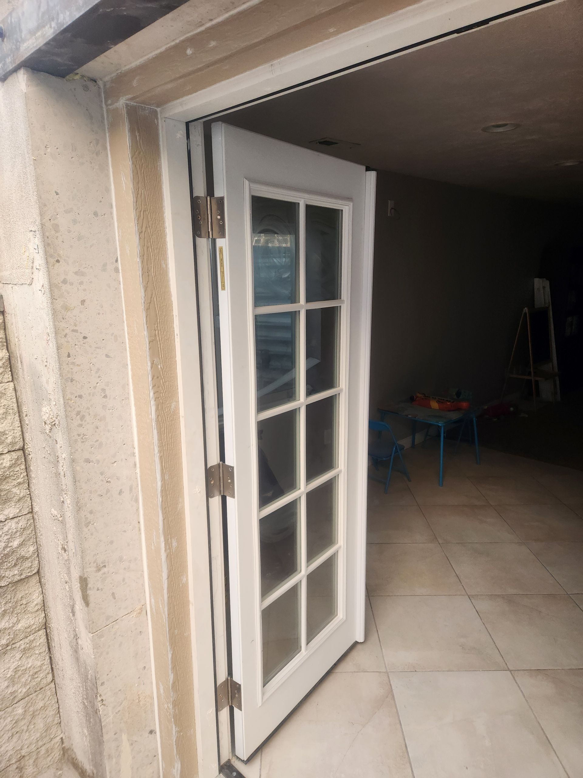White French door opening into a dim garage or basement interior.