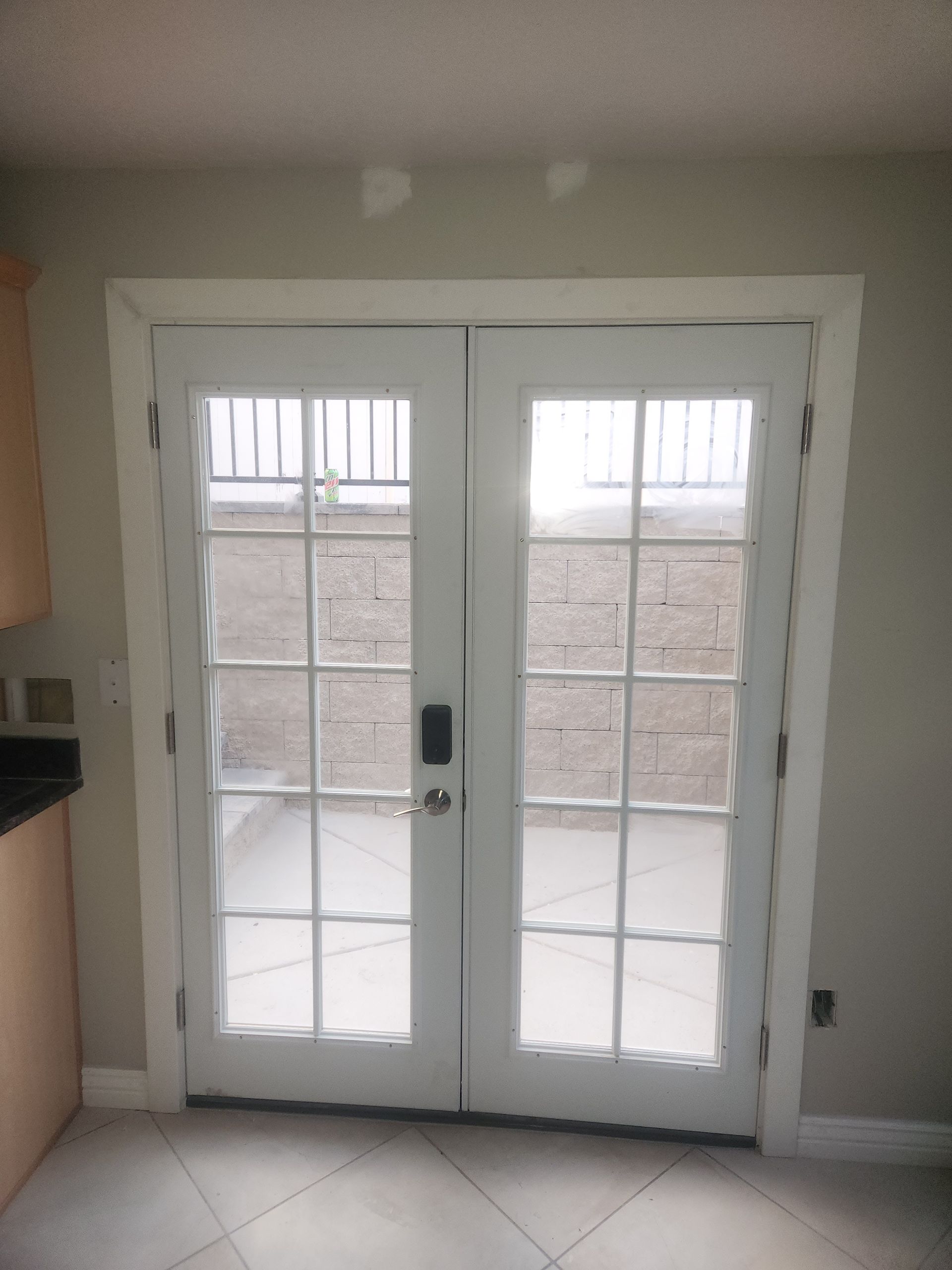 White French doors with glass panes opening to a stone patio in a bright interior room