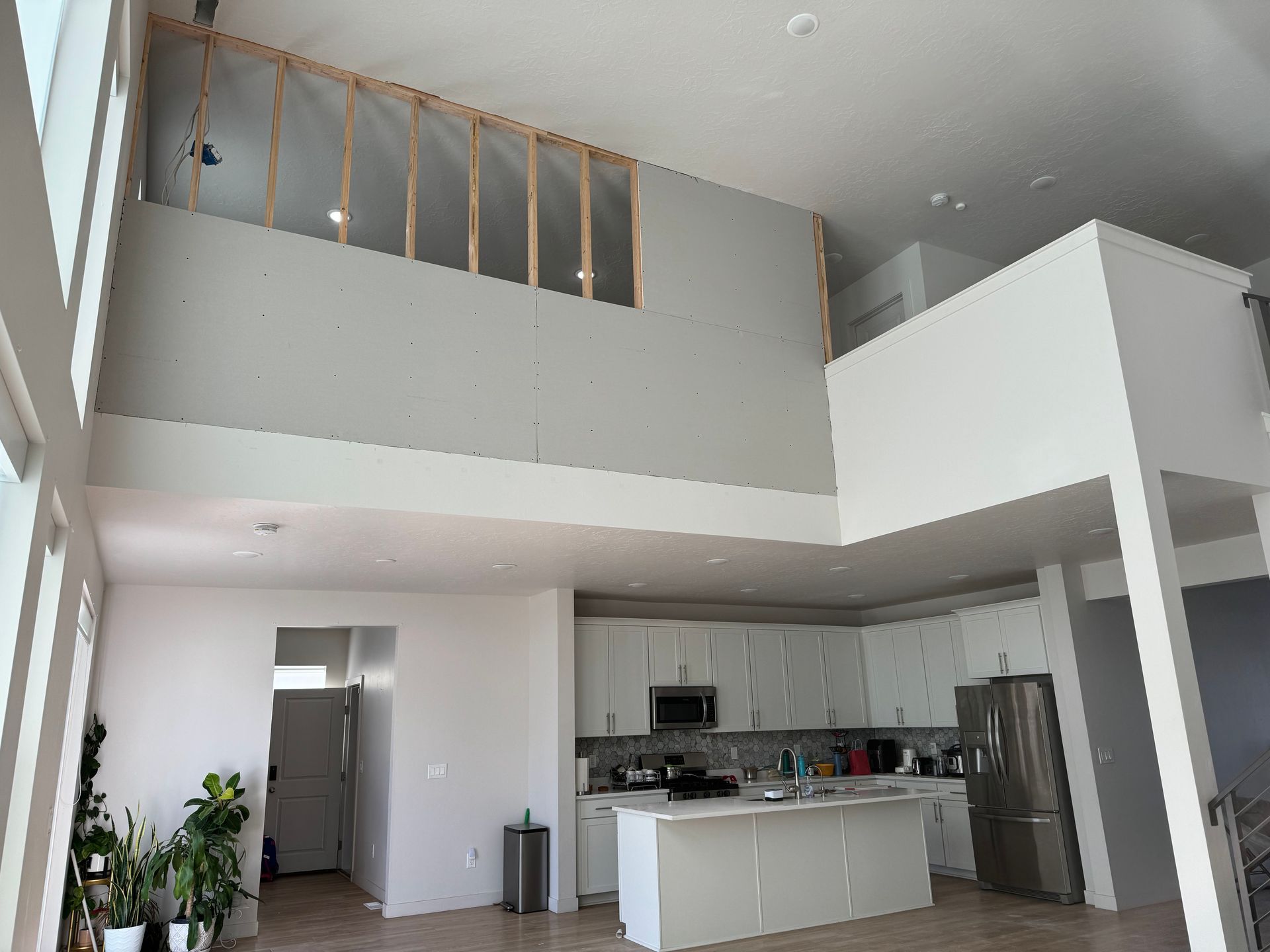 Bright open loft apartment interior with kitchen, mezzanine, and high ceilings
