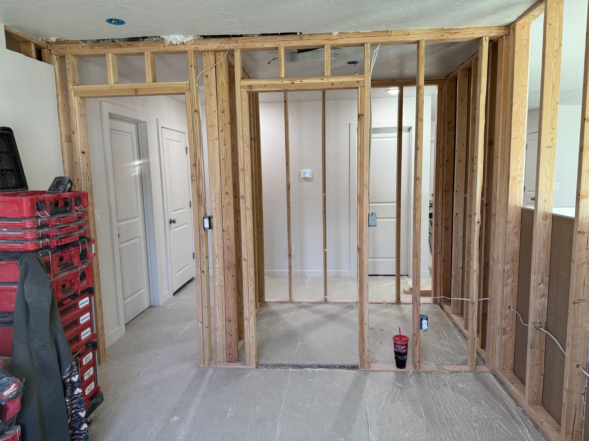 Room under renovation with exposed wooden wall framing and unfinished drywall