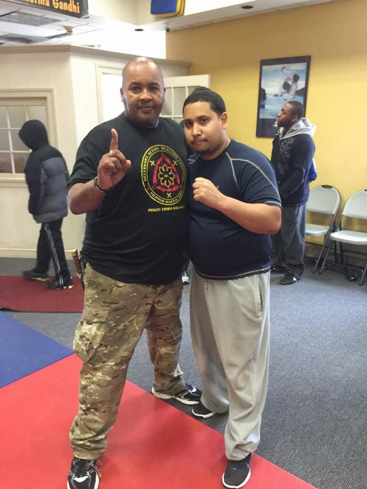 Two men standing next to each other with one wearing a shirt that says karate