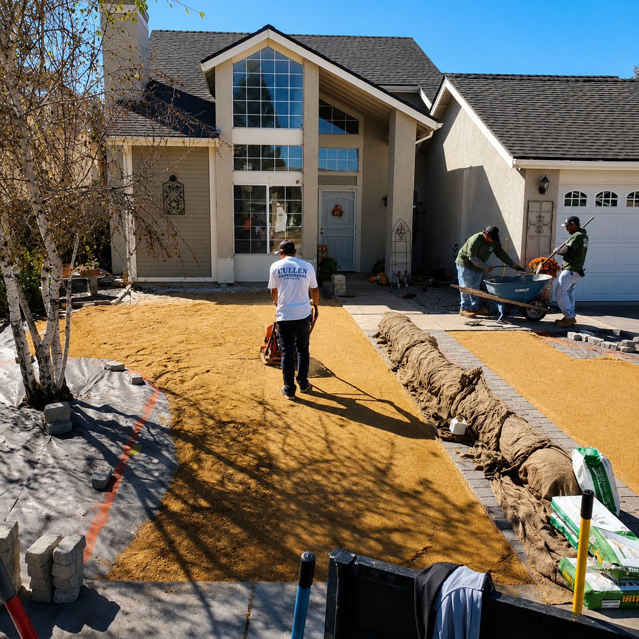 Workers landscaping a front yard beside a beige house with a large stone-lined path.