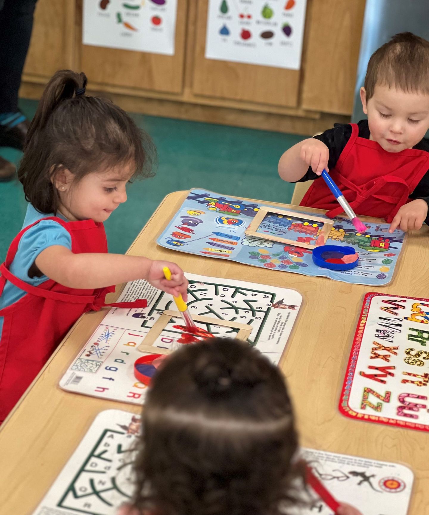a group of children are sitting at a table playing with toys .