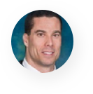 A man in a suit and tie is smiling in a circle.