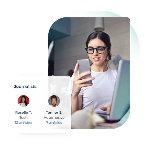 A woman is sitting in front of a laptop holding a cell phone.