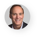 A man in a suit and tie is smiling in a circle.