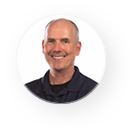 A man is smiling in a circle on a white background.