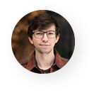 A young man wearing glasses and a plaid shirt is in a circle.