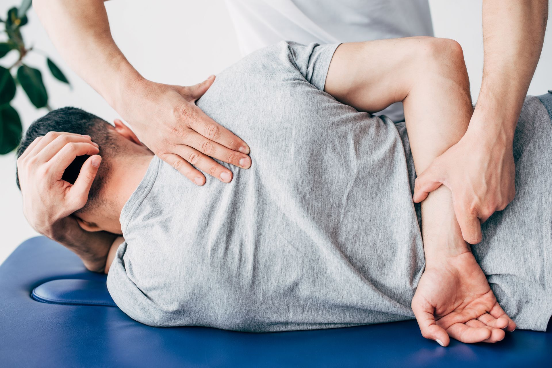 Chiropractor massaging the back of a man lying face down on a massage table