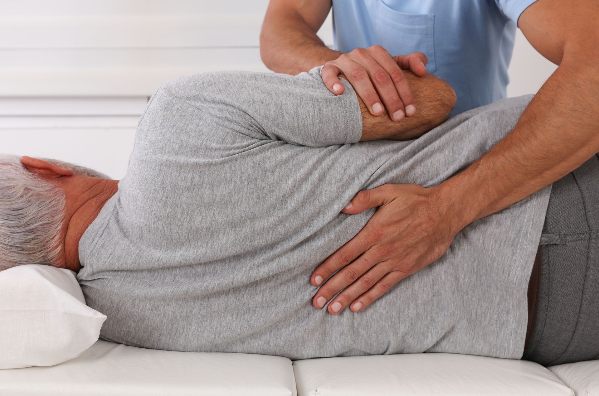 a physical therapist performing a shoulder and back stretch.