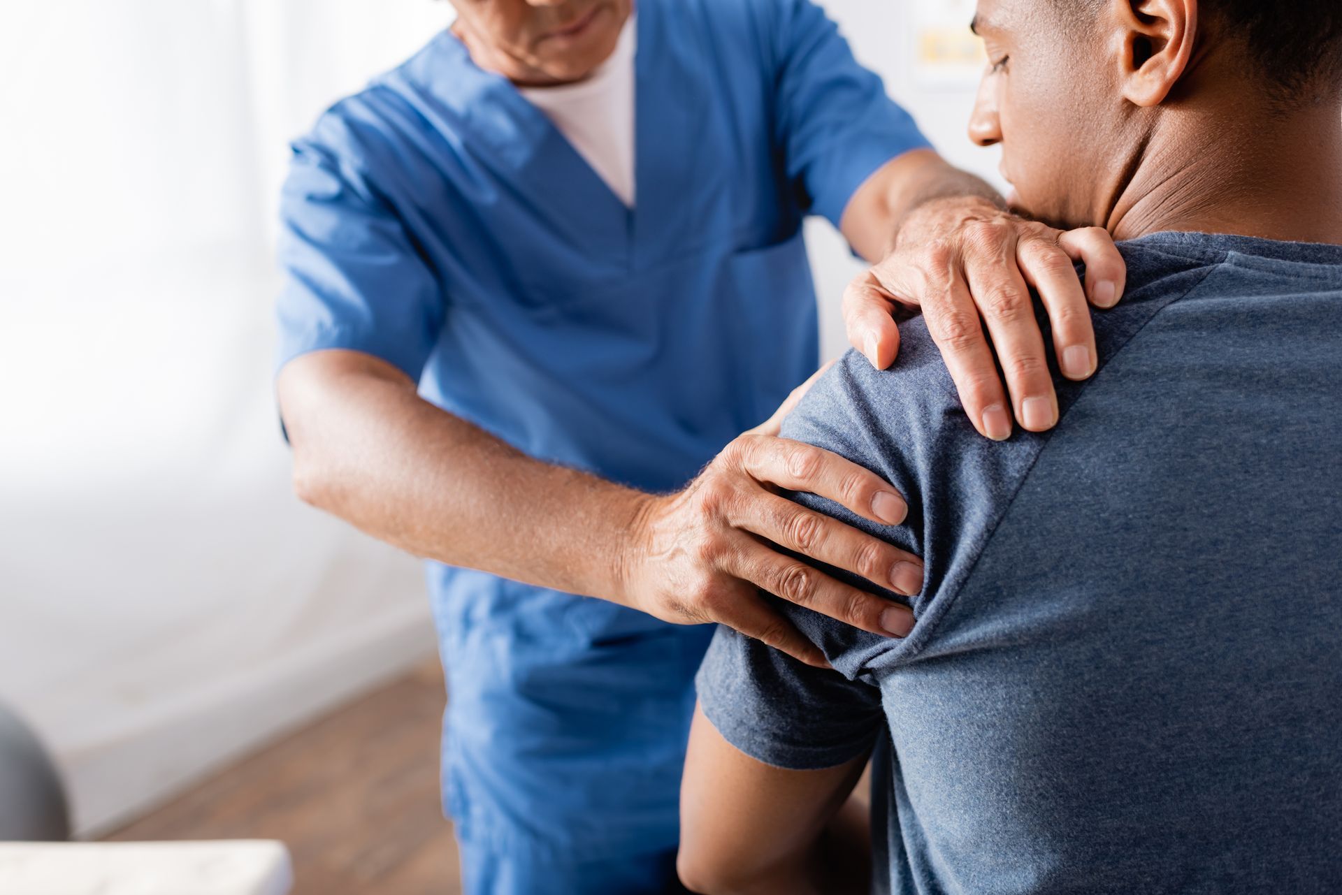 Physical therapist assessing shoulder mobility and joint function during a clinical examination.