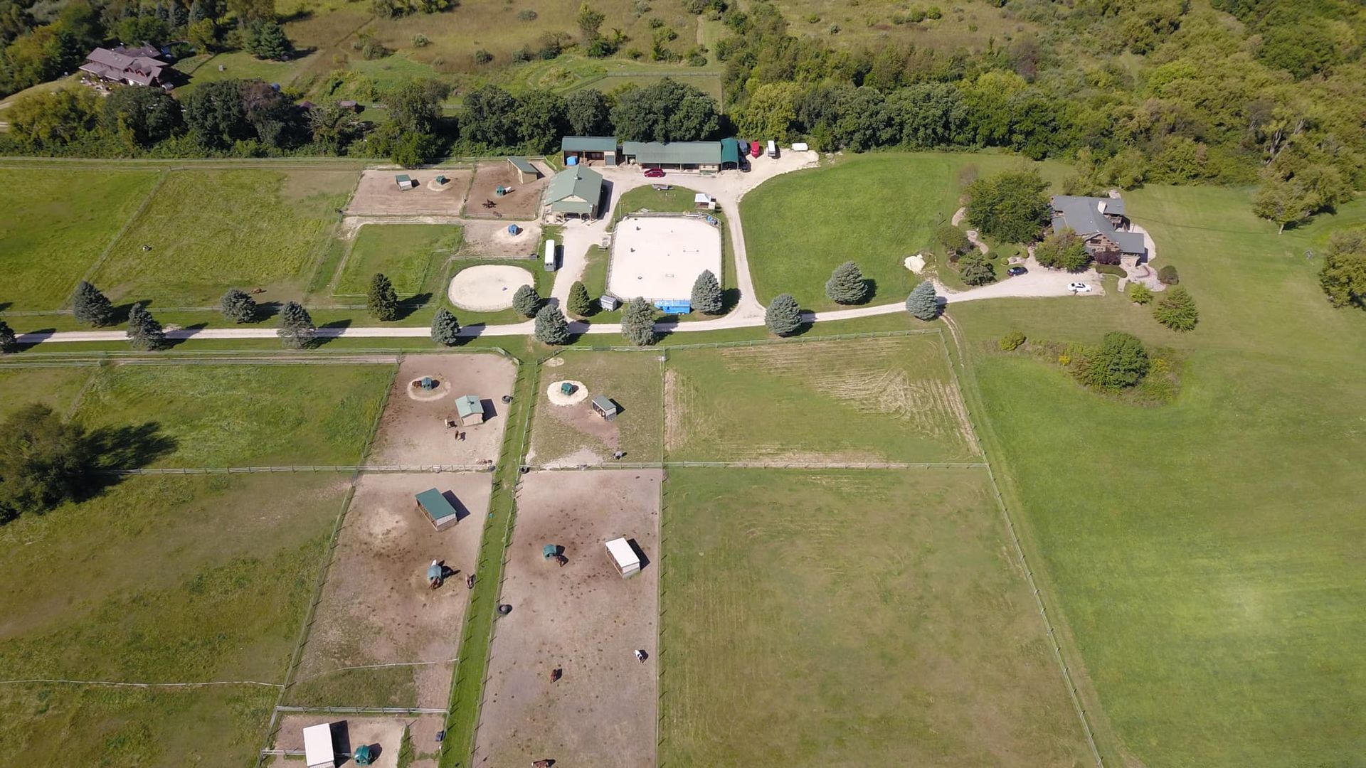 Aerial view of a rural farm with barns, fields, and a tree line
