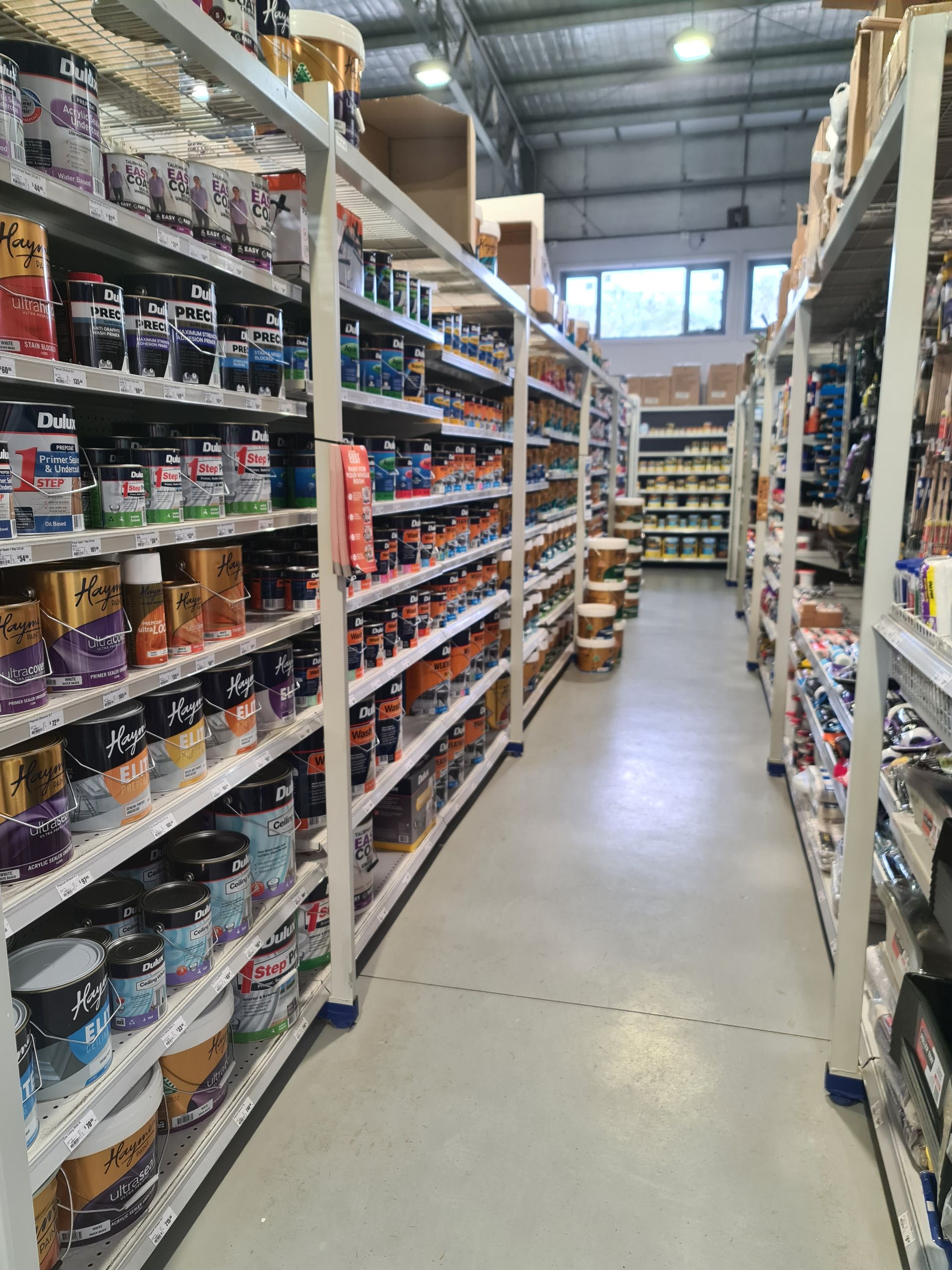 A warehouse filled with lots of buckets of paint.