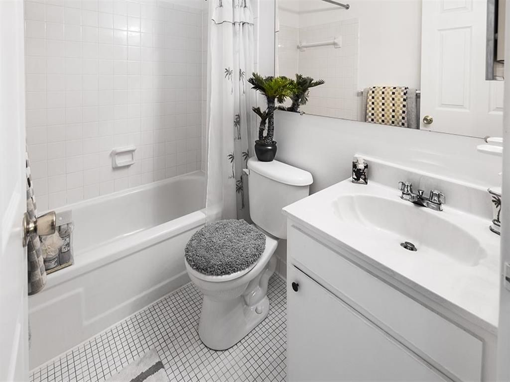 Compact apartment bathroom with bathtub/shower, toilet, and sink in white fixtures at Shadow Hill, offering apartments for rent in Sharonville, OH.