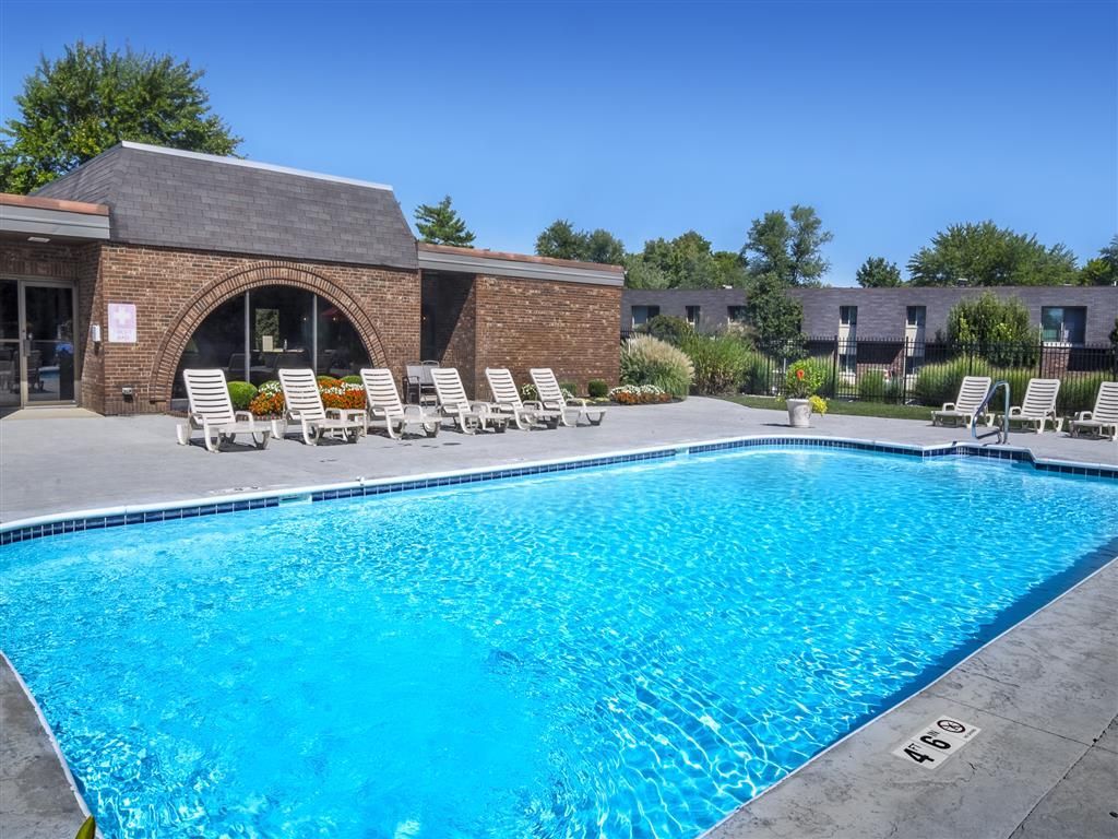 Outdoor apartment community pool with lounge chairs and surrounding landscaping at Shadow Hill, offering townhomes for rent in Sharonville, OH.