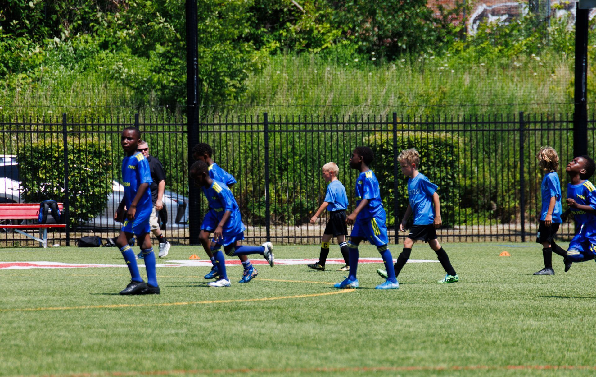 Soccer players in blue uniforms running on a grassy field during a match