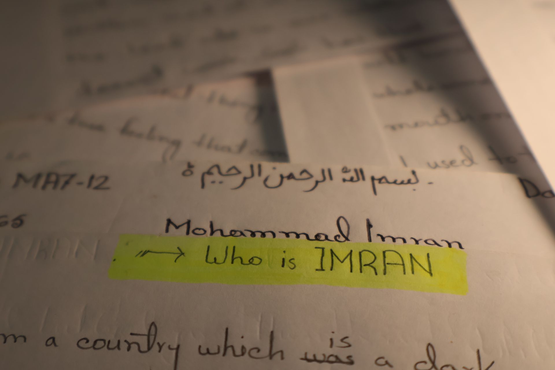 Handwritten notes on paper with a yellow highlighted line reading “Who is IMRAN?”