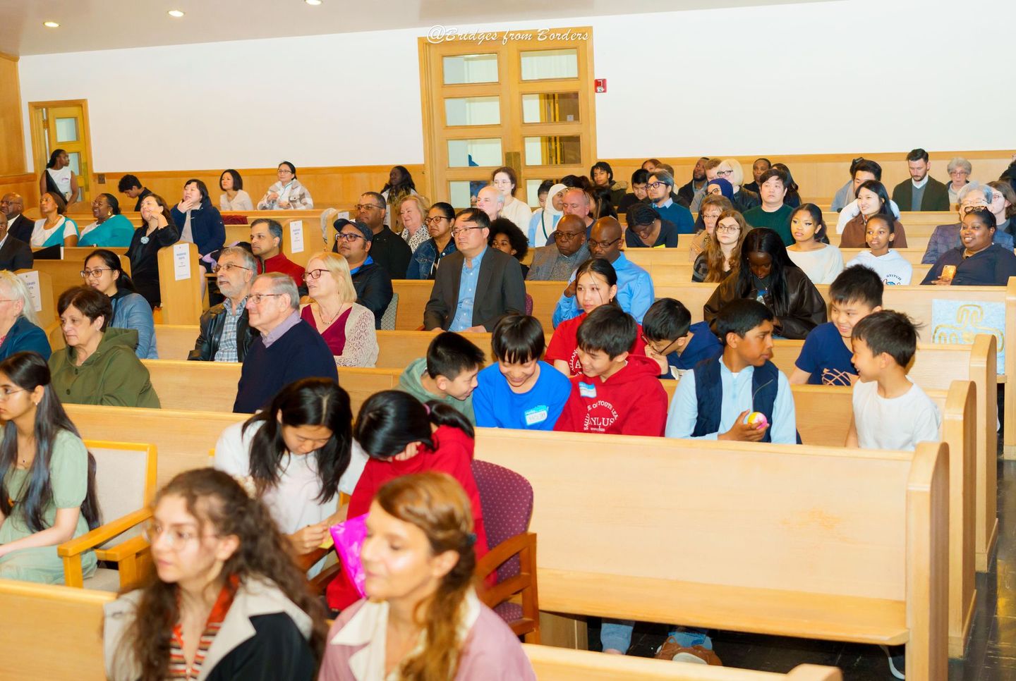 Audience seated in a lecture hall, listening during a group event