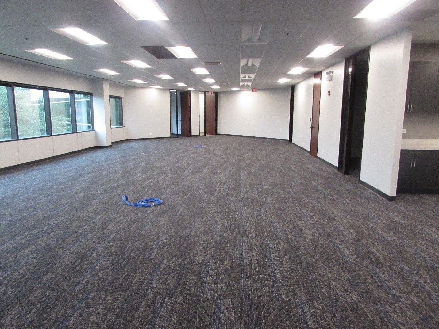 A large empty room with a carpeted floor and white walls