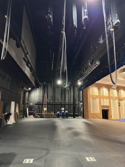 An empty auditorium with a blue curtain hanging from the ceiling