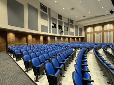Rows of blue seats in a large auditorium