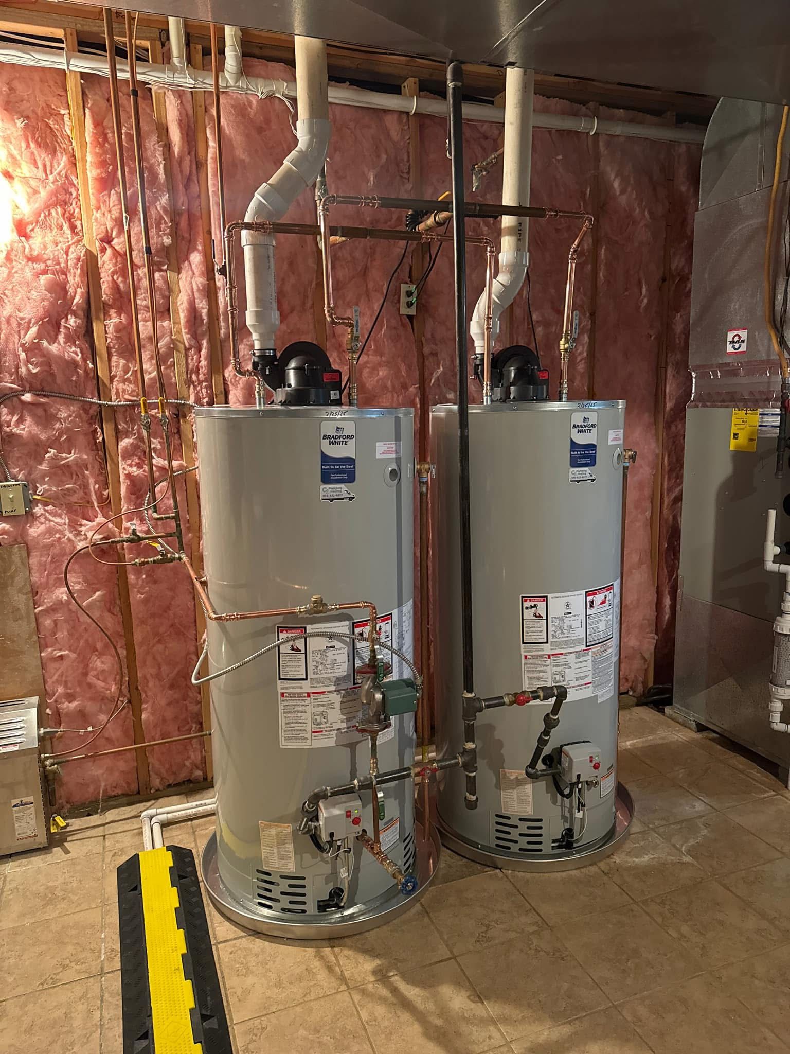Two water heaters are sitting next to each other in a basement.