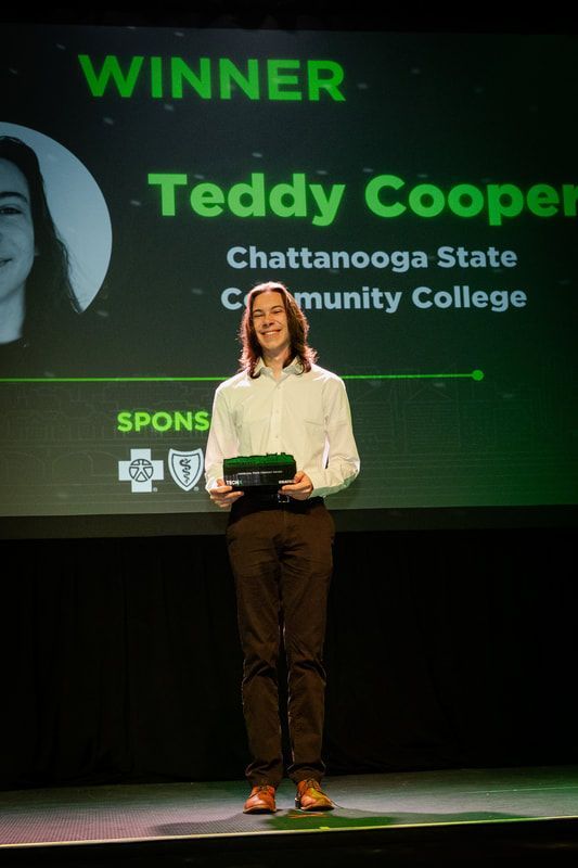 A man is standing on a stage in front of a screen that says winner teddy cooper