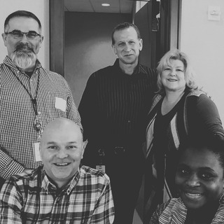 A black and white photo of a group of people posing for a picture