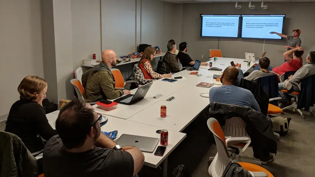 A group of people are sitting around a long table in a conference room.