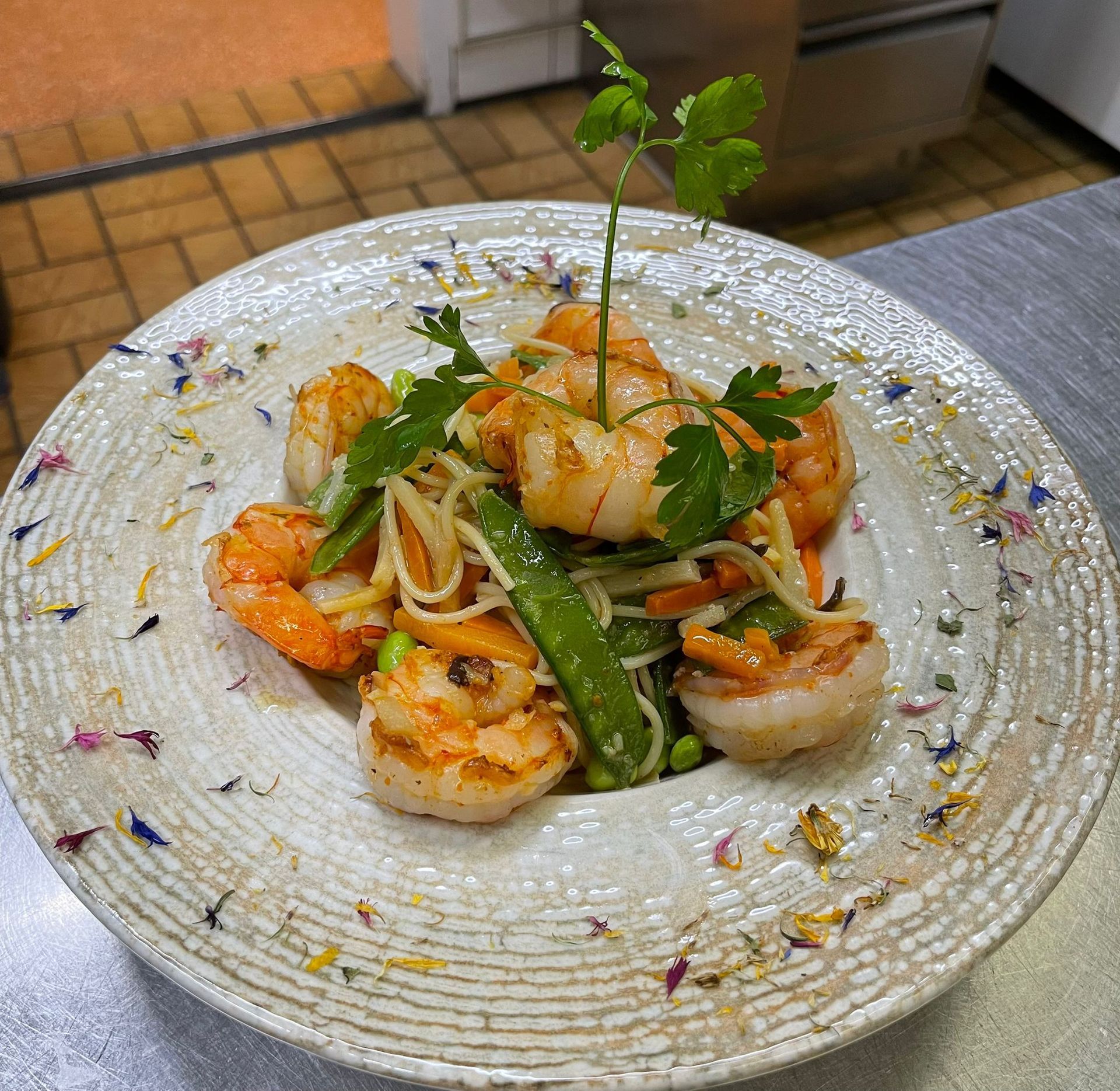 Une assiette de nourriture avec des crevettes et des nouilles sur une table
