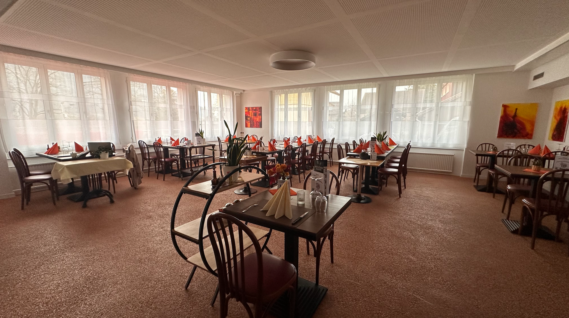 Une grande salle à manger remplie de tables et de chaises.