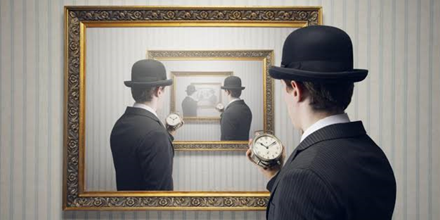 Man met horloge ziet zichzelf oneindig vaak terug in een spiegel.