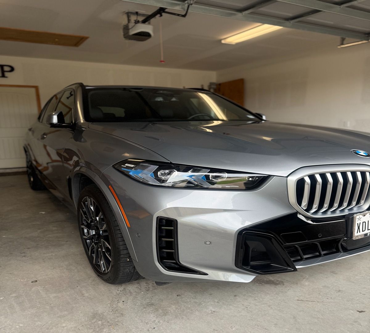 A silver BMW SUV parked inside a residential garage.