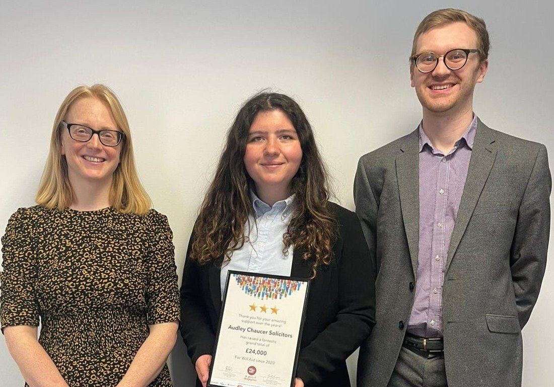 A man and two women are standing next to each other holding a certificate.