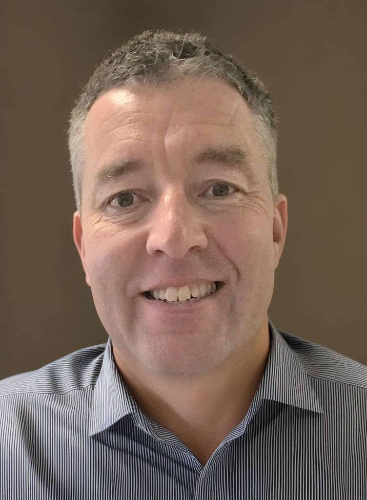 A man in a striped shirt is smiling for the camera.