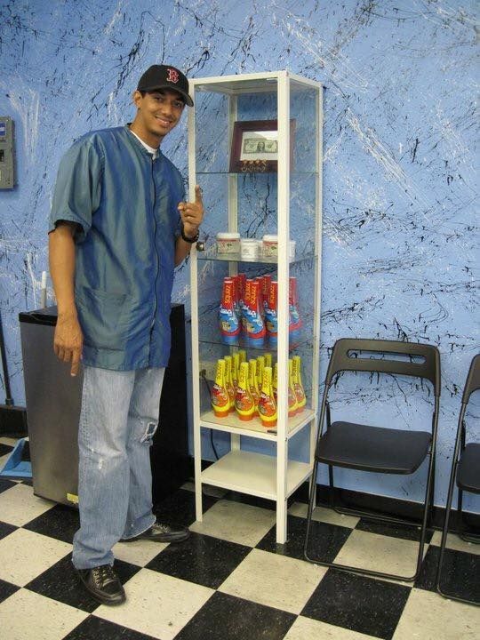 Man standing beside a white snack shelf stocked with colorful chips in a blue room with a checkered floor
