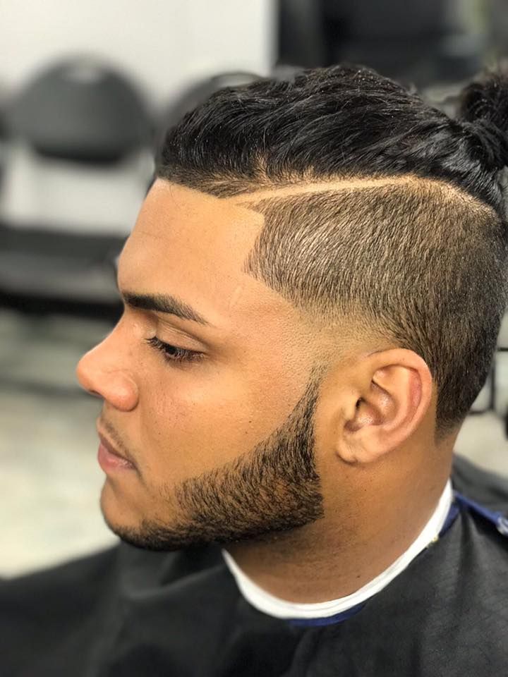 Side-profile haircut with faded sides and a defined line in a barbershop chair