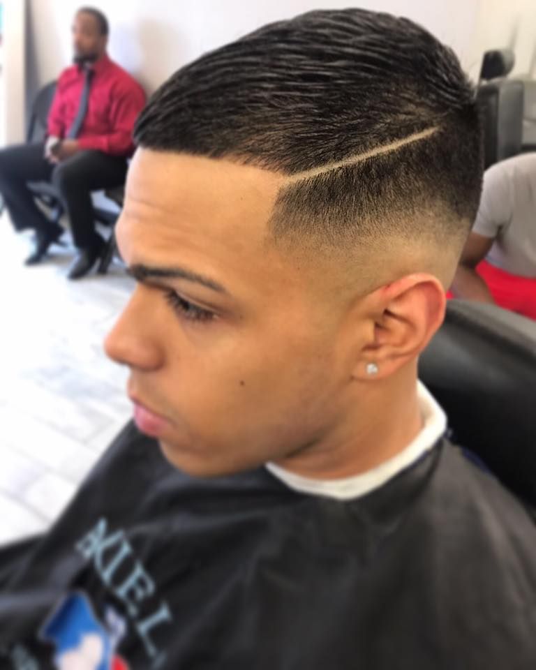 Close-up of a fresh fade haircut with a sharp lineup in a barber chair