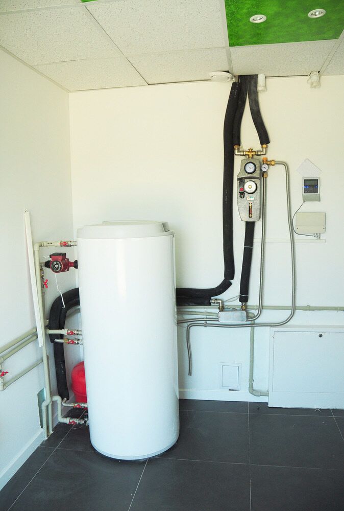 A White Water Heater is Sitting in the Middle of a Room — Daniel Gray Plumbing in Tumbulgum, NSW