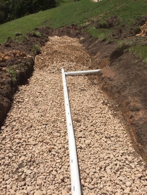 A White Pipe is Sitting on Top of a Pile of Gravel — Daniel Gray Plumbing in South Murwillumbah, NSW