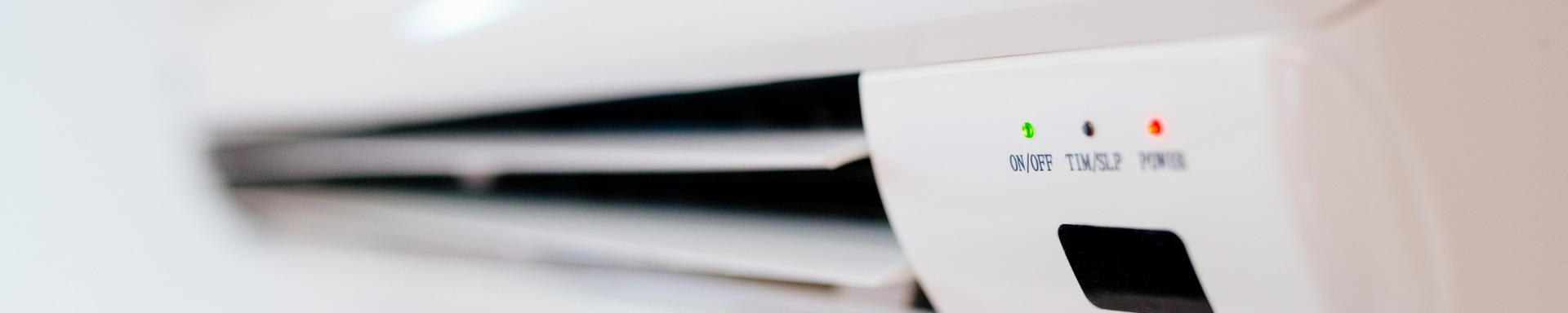 White printer with a lit green status light and red warning light on a desk