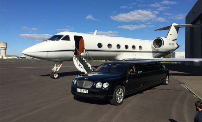 A limousine is parked in front of a private jet.