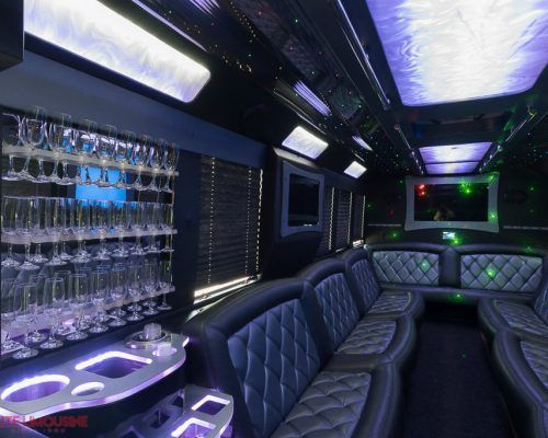 The inside of a limousine with a bar and wine glasses