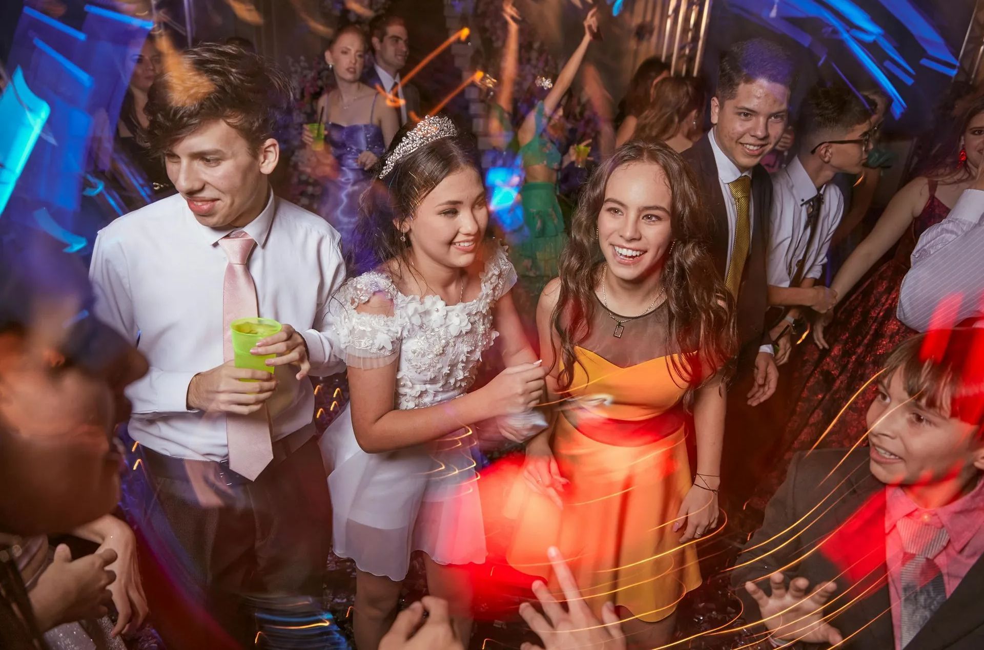 A group of people are dancing at a party in a club.