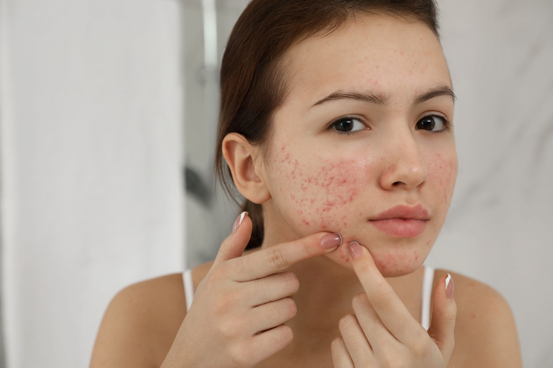 a woman touching her face.