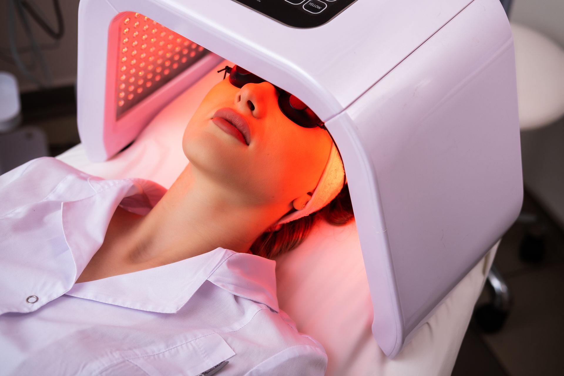 A woman is getting a facial treatment with a machine on her face.