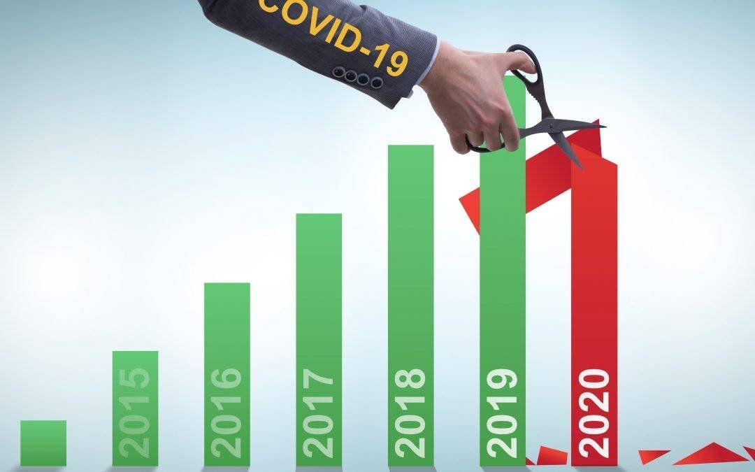 a person is cutting a graph with scissors that says covid-19