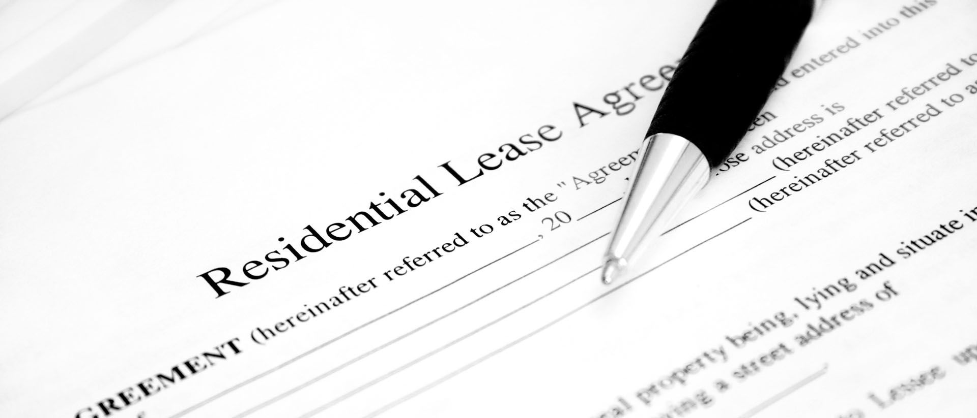 A pen is on top of a residential lease agreement