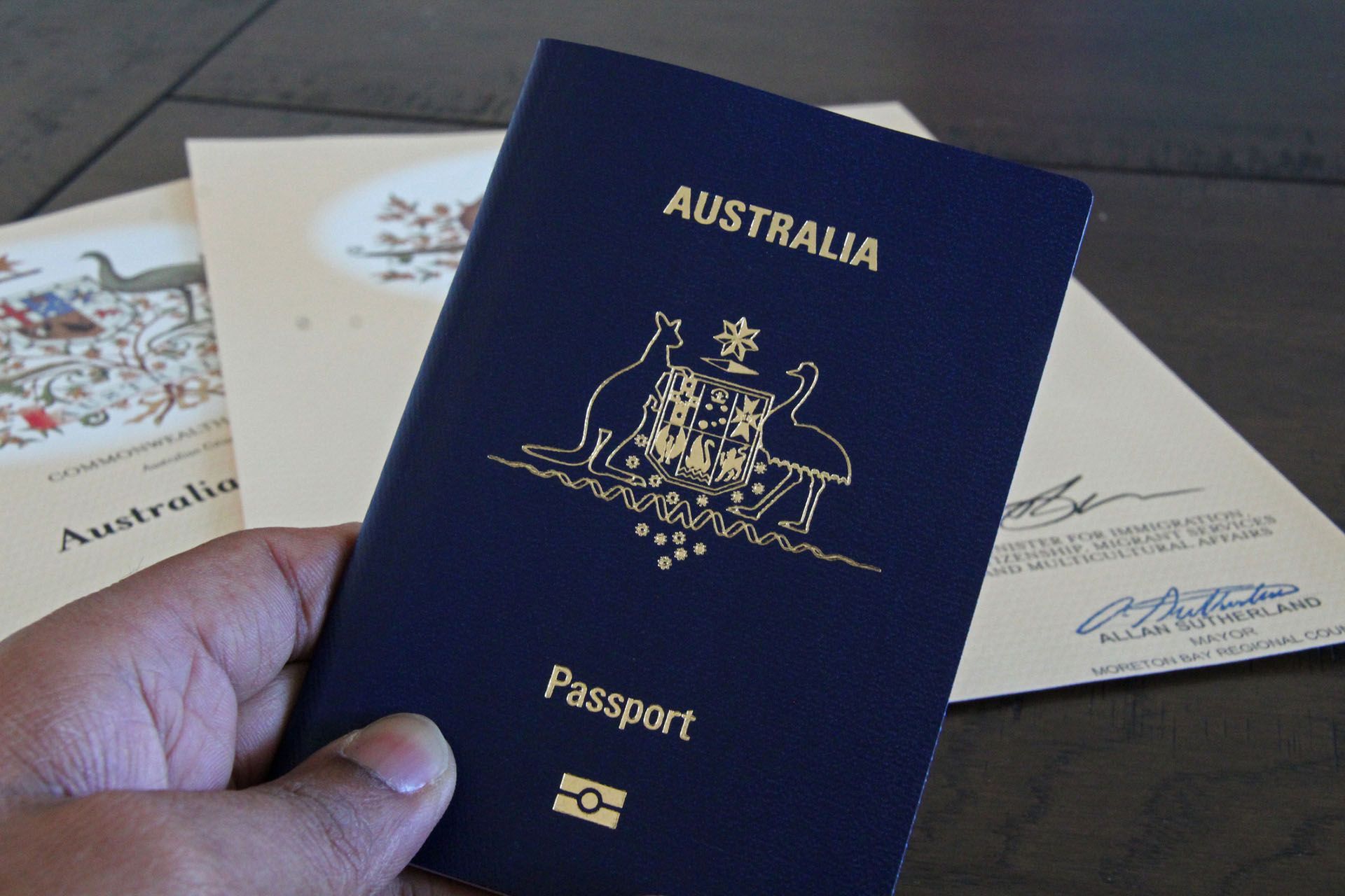 a person is holding an australia passport in their hand